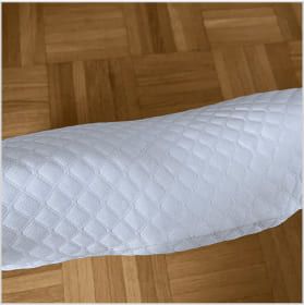 Close-up of a textured white sleeve on a wooden floor.